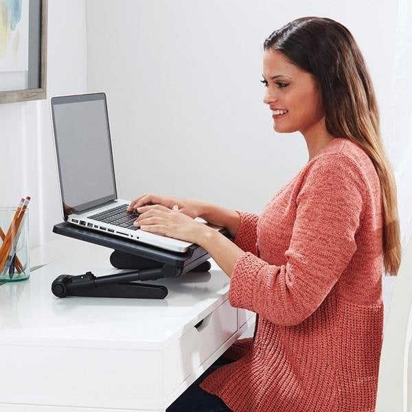 Woman sitting at desk using laptop that is on an AirSpace