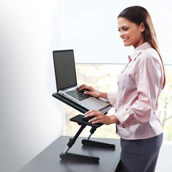 Woman standing and using laptop and mouse that are on an AirSpace Laptop Desk with legs fully extended