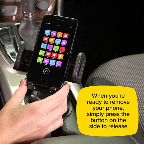 Smart phone in a Cup Call that is in a cup holder inside a car with the sides fully extended out. Text says when you're ready to remove your phone, simply press the button on the side to release