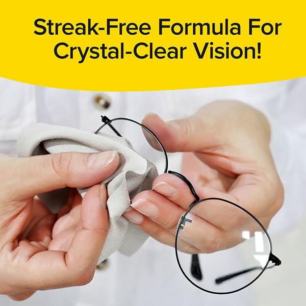 Close up of someone holding glasses and wiping them with cloth. Text says "Streak Free Formula For Crystal Clear Vision!"