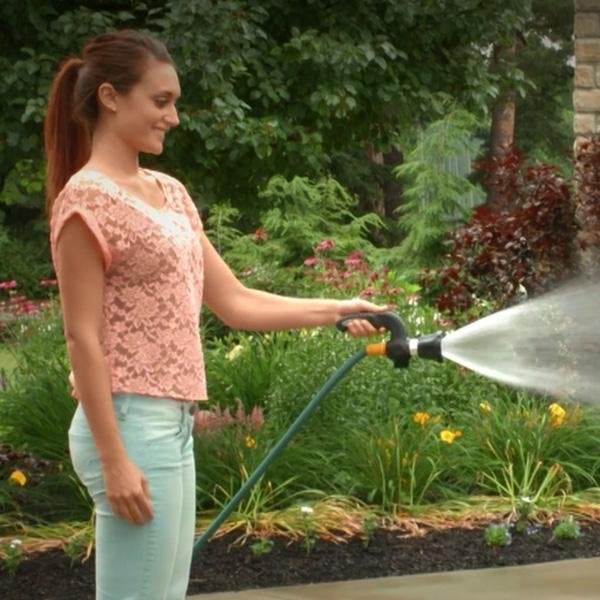 Woman using Mighty Blaster on hose to spray water